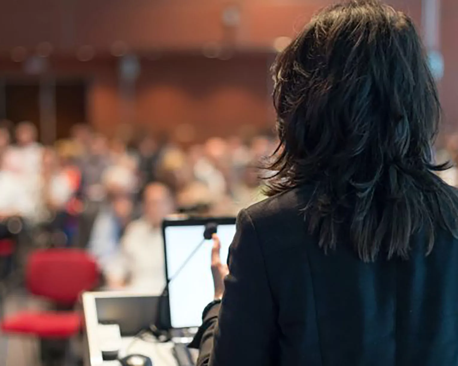 A confident woman speaks at a podium