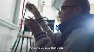 Black student with glasses sets up an experiment in a classroom with subtitle "And the union is that voice."