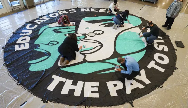 Art build with the text "educators need the pay to stay"